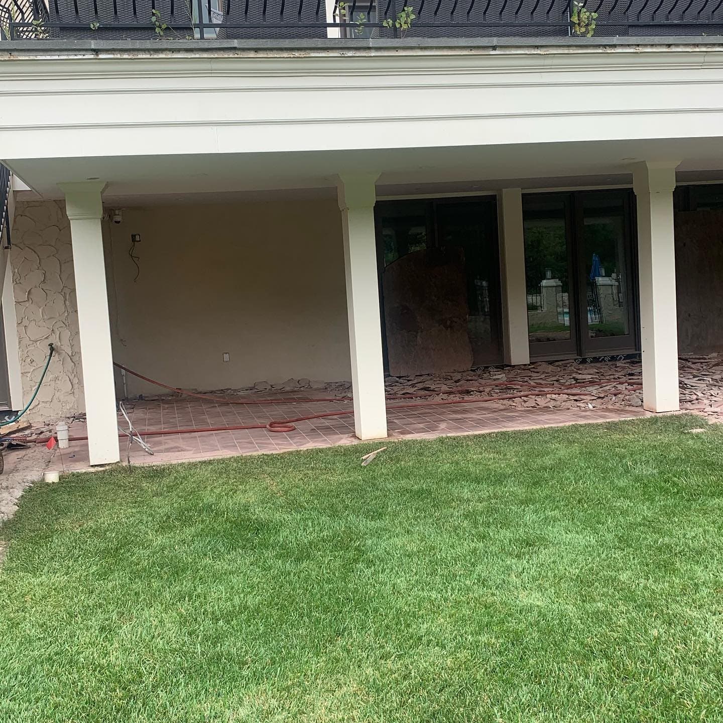 Thick, freshly mowed lawn under a covered deck
