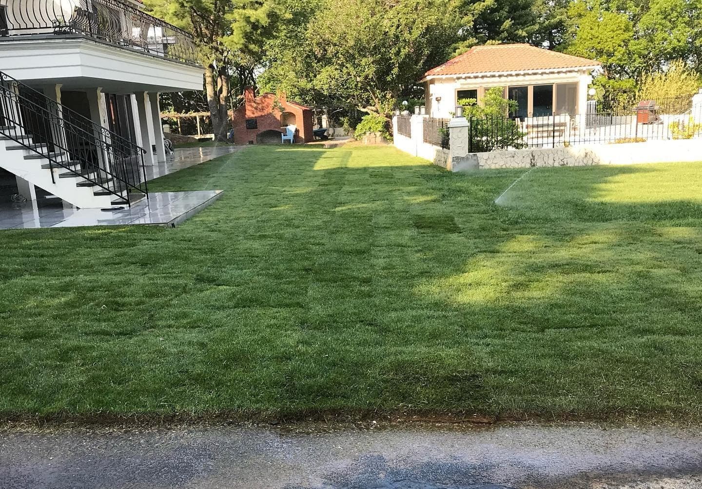 Freshly laid lawn by a pool house